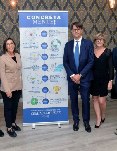 Fabio Lunghi insieme ai delegati di Concretamente vicino al tabellone di presentazione dell'associazione