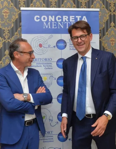 Fabio Lunghi insieme ad un delegato entrambi vicini al tabellone di presentazione dell'associazione